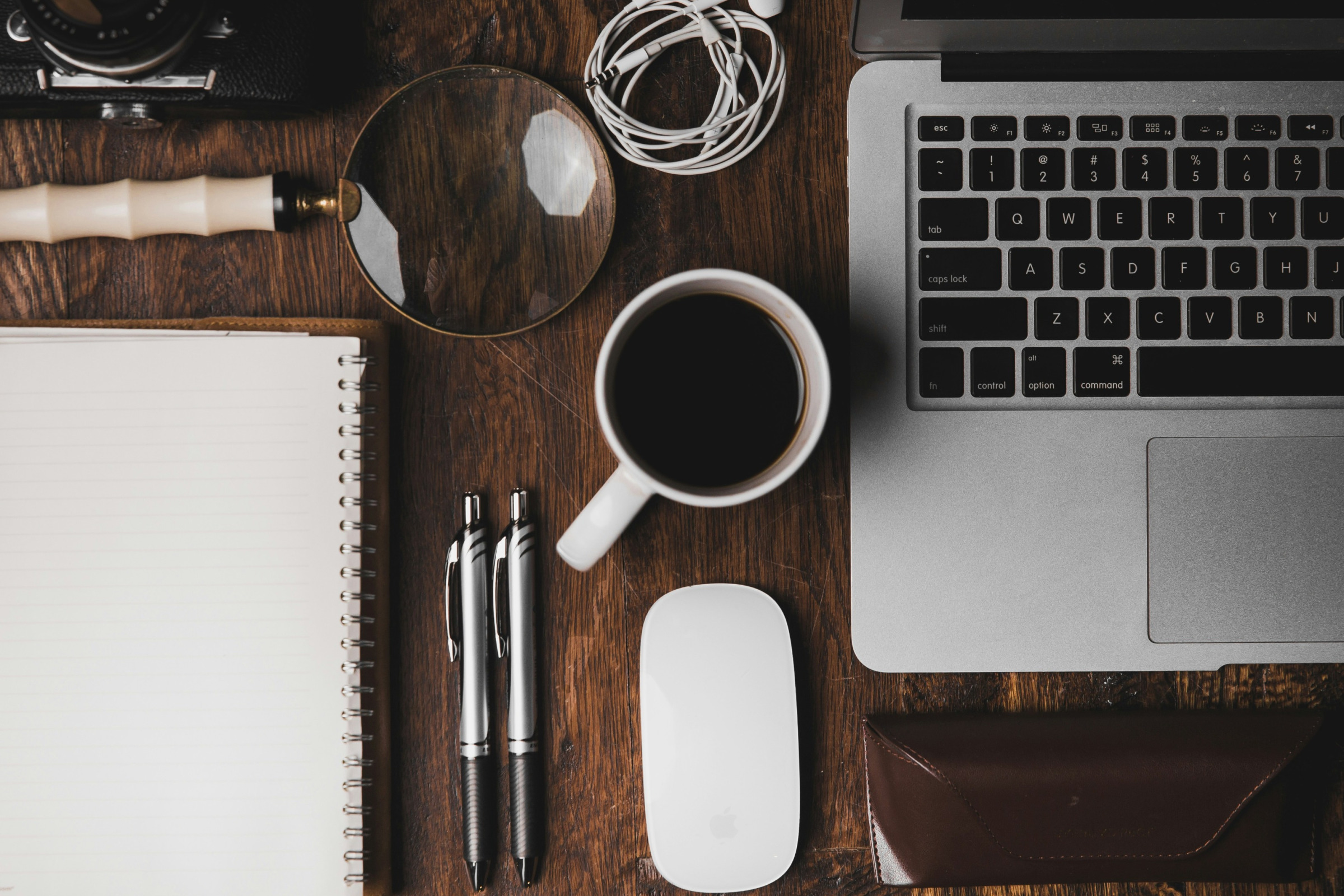 Laptop, coffee, and magnifying glass on a desk